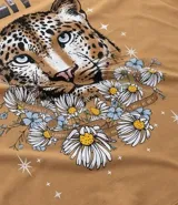 Remera alargada de algodón color ocre, con cuello redondo y mangas cortas. Presenta un estampado de la cara de un leopardo rodeada de flores y la frase "Starlit Sky".