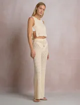 Pantalón de tiro alto con tejido calado y textura labrada, de corte recto con apertura acampanada hacia el ruedo. Cuenta con cintura elastizada y cordón de ajuste con terminaciones de caracoles decorativos.