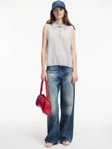 Chaleco de cashmere color gris claro, con cuello polo y cierre de botones.