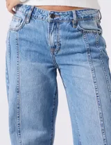 Jean de tiro medio y calce relajado, color azul claro, con bolsillos delanteros y traseros. Presenta recortes verticales en el frente y un recorte horizontal en el ruedo.
