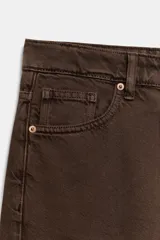 Jeans de tiro medio con corte relajado y diseño de cinco bolsillos. Presenta trabillas en la cintura, cierre frontal con cremallera y botón metálico, con un acabado de lavado desgastado.