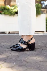 Zapatos negros de charol con taco cuadrado y tira sobre el empeine con hebilla metálica. Calzado de cuero hecho a mano en Uruguay.