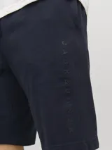 Short jogger de tejido de sudadera color azul marino, con fit relajado, cintura elástica con cordón ajustable y detalle de logo impreso en el lateral.