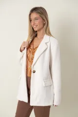 Blazer italiano color beige, de corte recto, con solapas de muesca, cierre de un botón y bolsillos simulados.