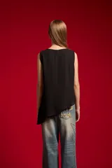 Musculosa de poliéster color nude, con cuello redondo y diseño asimétrico sin mangas.