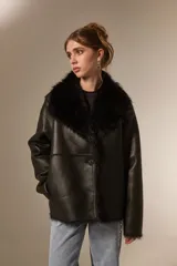 Chaqueta de eco-cuero color beige con interior y cuello de piel sintética al tono. Presenta un diseño holgado, cierre frontal con un botón y solapas amplias.