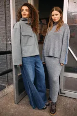 Sweater tejido de manga larga con cuello alto, hombros caídos y detalle de línea contrastante sobre las mangas, de fit holgado y textura gruesa.