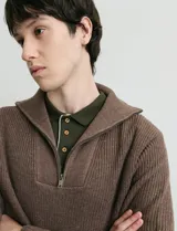Remera de punto inglés con manga larga y medio cierre frontal metálico. Presenta cuello en punto canalé y diseño de tejido texturizado.