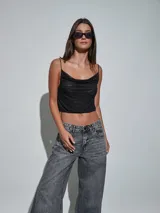 Top negro de tirantes finos con escote drapeado y detalle de pequeños brillos distribuidos en la prenda, diseño corto tipo crop top.