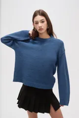 Sweater de tejido de punto color azul, con cuello redondo, manga larga y diseño holgado.