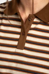 Remera polo de manga corta con diseño a rayas horizontales en tonos marrones, beige y negros, cuello en contraste y cierre frontal de botones.