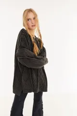 Sweater oversize unisex de tejido de punto con diseño de ochos y efecto lavado. Presenta cuello redondo, mangas largas y una franja central con letras en relieve.