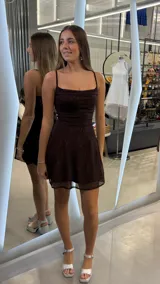 Vestido corto marrón con detalle de brillos dorados, escote drapeado y tirantes finos.