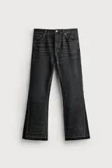 Jeans flare fit de denim negro, tiro medio, ajustados arriba y con botamanga acampanada. Cuentan con cinco bolsillos, lavado efecto gastado y bajo con acabado irregular. Cierre frontal con cremallera y botón.