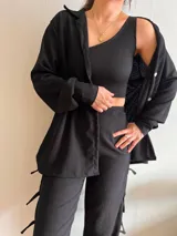 Camisa negra de manga larga con botones y cuello clásico.