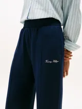Pantalón de jogging azul marino de pierna ancha, con costura marcada frontal y logo bordado en blanco en el muslo.