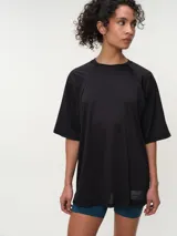 Remera deportiva de color rosado con diseño oversized y mangas raglán cortas, confeccionada en tela dry fit. Cuenta con cuello redondo clásico y detalle de etiqueta en el lateral inferior.
