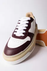 Championes urbanos Urban Haus modelo Mauro, con diseño de paneles en cuero blanco y gamuza verde oliva. Presentan suela de plataforma de goma en tono beige, cierre con cordones blancos y logo de la marca grabado en el lateral.