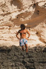 Short de baño con estampado geométrico en tonos turquesa, naranja y beige. Cuenta con cintura elástica, dos bolsillos laterales, un bolsillo trasero y red interior hipoalergénica.