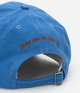 Gorra azul de sarga con visera curva, ajuste trasero y bordado de estrella de mar color naranja.