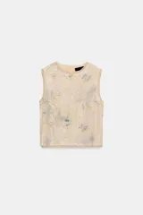 Top corto sin mangas, con cuello redondo, confeccionado en tejido de punto cubierto de lentejuelas con estampado floral en tonos azules y verdes sobre fondo beige. Cuenta con cierre en la espalda con abertura y botón.