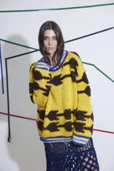 Sweater tejido a mano en lana color amarillo con diseño abstracto en marrón y detalles en azul en cuello y puños. De calce holgado, cuello a la base y puños ajustados.