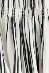 Vestido midi de mezcla de viscosa, con estampado de rayas verticales en blanco y negro, escote recto, cuerpo fruncido tipo nido de abejas, breteles finos con lazo y falda con vuelo.