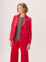 Blazer negro de simil terciopelo con cuello y puños en color marrón. Tiene bolsillos delanteros y forro estampado.