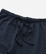 Pantalón de pijama tipo jogger color azul marino, con cintura elástica y cordón de ajuste. Presenta puños elásticos en los tobillos y un acabado jaspeado.