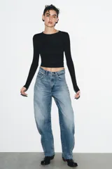 Camiseta de manga larga en color marrón oscuro, confeccionada en tejido de algodón. Presenta un diseño de corte ajustado (slim fit) con cuello redondo.