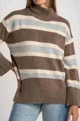 Polera de tejido de punto con diseño a rayas horizontales en tonos marrón, beige y gris. Presenta cuello alto, mangas largas con puños anchos y un corte holgado.