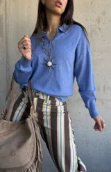 Sweater de punto celeste con cuello polo, cierre frontal parcial con botones y textura geométrica tipo rombos.