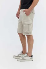 Bermuda cargo color beige de corte recto, con bolsillos laterales amplios con solapa y bolsillos traseros. Presenta largo a la rodilla y costuras definidas.