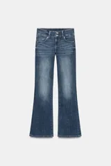 Jeans de tiro bajo y cintura ancha, con diseño bootcut de corte evasé desde la rodilla. Cuenta con cinco bolsillos y cierre frontal con cremallera y dos botones metálicos. Color azul con efecto desgastado.