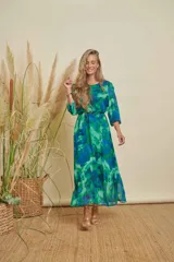 Vestido midi con estampado abstracto en tonos verdes y azules, cuello redondo, mangas tres cuartos y lazo ajustable en la cintura.