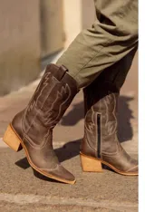 Bota texana blanca de cuero con bordados decorativos y taco de madera.