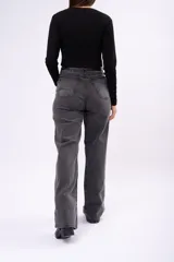 Pantalón de jean corte wide leg en color negro gastado, con tiro alto y estructura rígida.