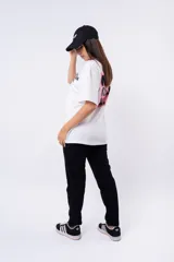 Remera negra de corte oversize con estampado frontal que dice "MIJA DREAM BIG" en tipografía blanca y rosa.