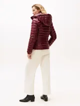 Campera de corte slim con acabado brillante, repelente al agua y diseño acolchado. Cuenta con capucha extraíble, cuello levantado, cierre frontal de cremallera, dos bolsillos laterales con cierre y puños elásticos. Incluye el logo de la marca bordado en el pecho.