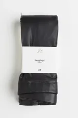 Calza de cuero sintético color negro, de tiro alto y corte ajustado.