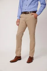 Pantalón de vestir color beige, confeccionado en algodón con spandex. Corte recto, con bolsillos laterales y traseros. Se ajusta a la cintura con cinturón de cuero trenzado en tonos azul y beige.