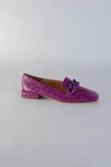 Mocasines verdes con textura símil piel de reptil y detalle de cadena plástica en el empeine.