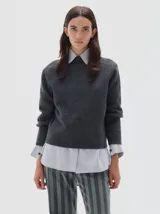 Polera de punto gris oscuro, de corte clásico y cuello redondo, con textura suave y logo bordado sutil en el pecho.