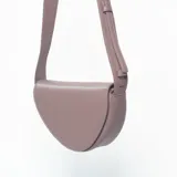 Bandolera de diseño semicircular en color rosa, con correa larga ajustable y cierre superior.