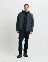 Campera tipo softshell color gris oscuro, con capucha ajustable, cierre frontal completo y bolsillos laterales y en el pecho con cierre.