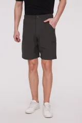 Bermuda de corte recto y diseño minimalista, confeccionada en tejido técnico de poliéster. Presenta cintura elástica con cierre de botón frontal, bolsillos laterales y un bolsillo pequeño adicional en el lateral izquierdo.