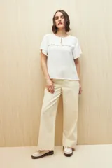 Blusa negra con textura, canesú con encaje, volados, corte fluido y mangas cortas amplias.