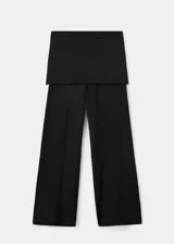 Pantalón de punto fino color negro, de diseño recto y tiro medio, con falda corta superpuesta integrada.