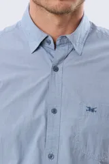 Camisa de manga corta de algodón en color celeste con microdiseño geométrico a cuadros, cuello camisero y bolsillo frontal con logo bordado.
