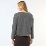 Sweater de punto color gris, de corte recto y largo a la cintura. Presenta cuello redondo y detalle de botones decorativos dorados en uno de los hombros.